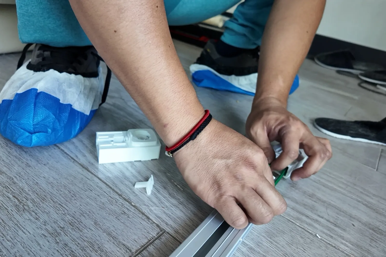 穿着鞋套的安装人员正在组装电动轨道组件
